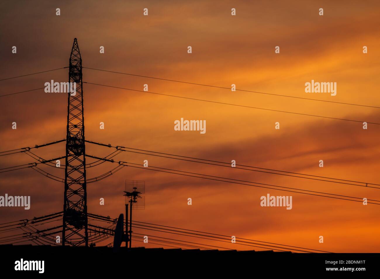 silouette di un polo di potenza con cielo arancione e giallo sullo sfondo Foto Stock