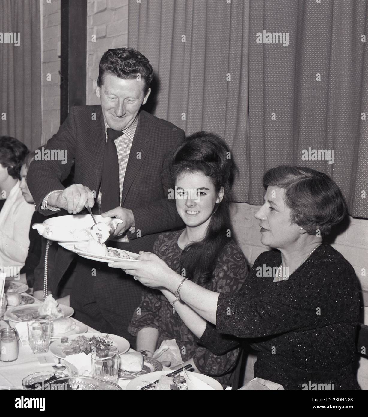 1965, storico, donne ospiti che sono serviti cibo in un club sociale cena, Inghilterra, Regno Unito. Foto Stock