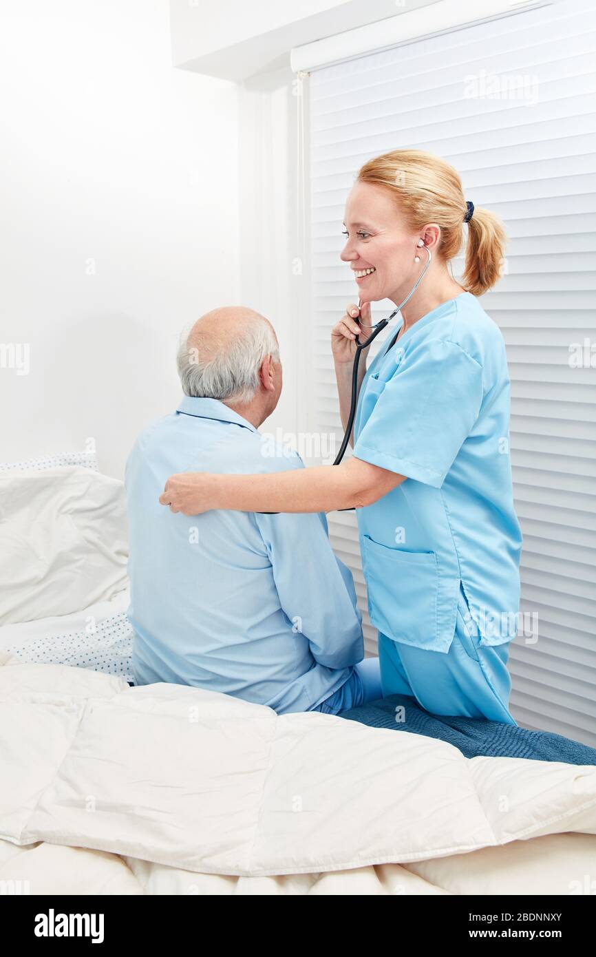 L'infermiere ascolta il paziente con stetoscopio nella casa di cura Foto Stock