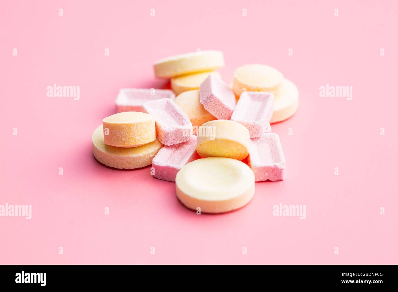 Mix di caramelle dure e colorate su sfondo rosa. Foto Stock