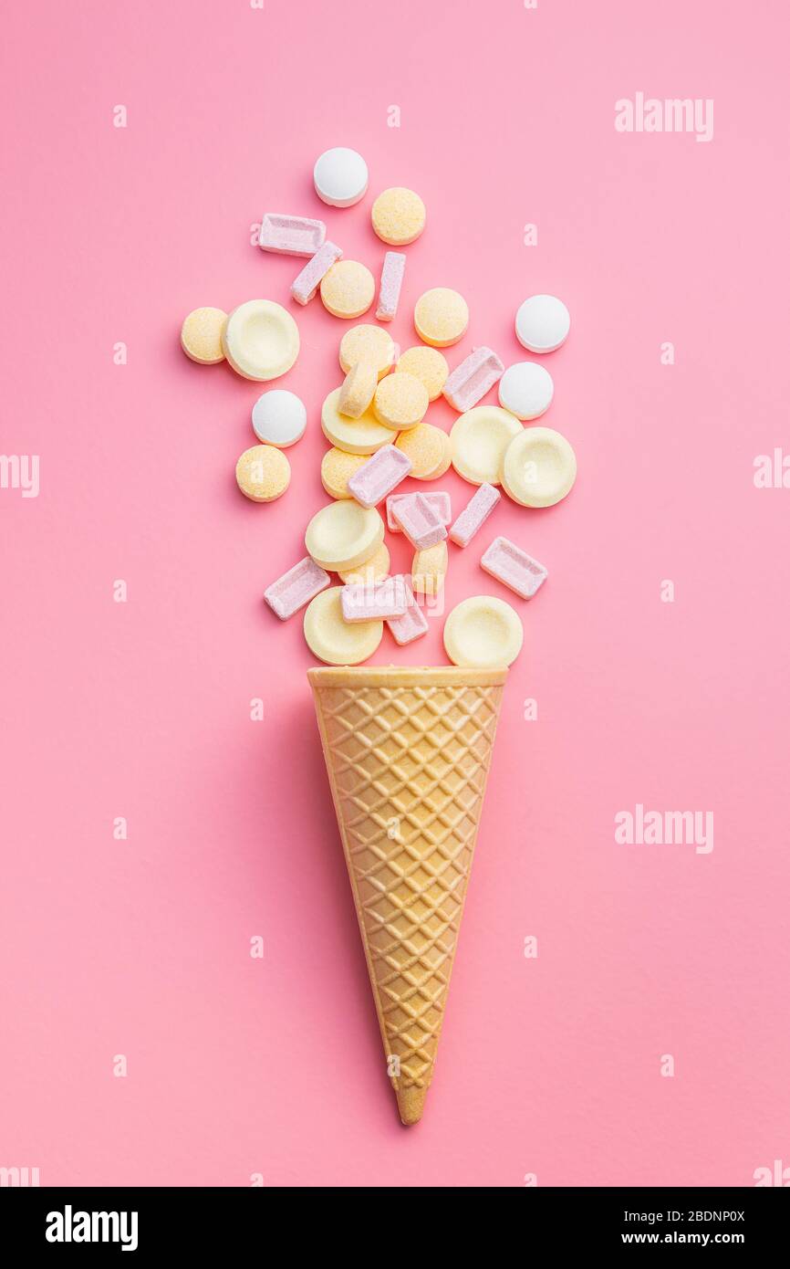 Mix di caramelle colorate dure in cialda di gelato su fondo rosa. Vista dall'alto. Foto Stock