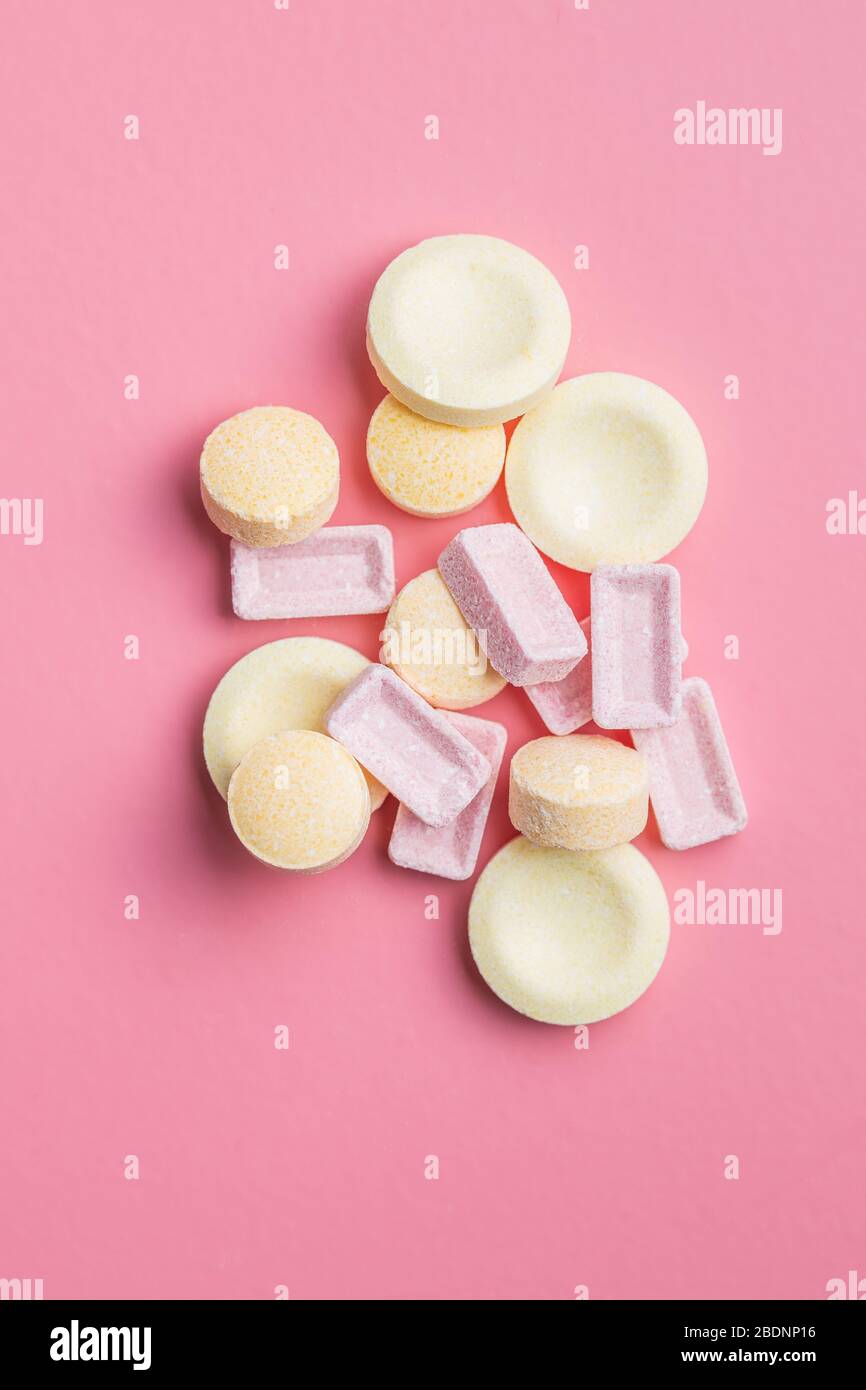 Mix di caramelle dure e colorate su sfondo rosa. Vista dall'alto. Foto Stock