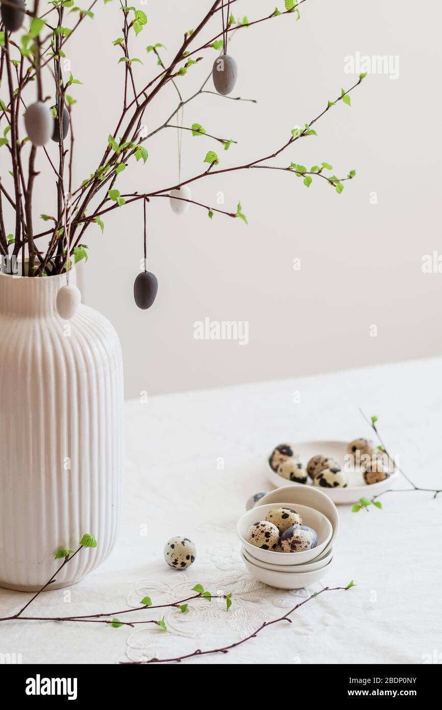 Tavolo di astro decorato con albero di Pasqua e uova di quaglia. Moderno decor minimalista di Pasqua Foto Stock