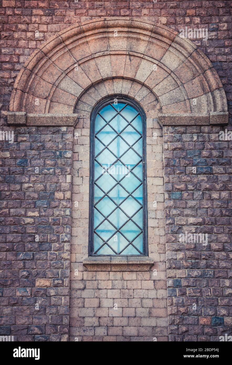 Finestra ad arco a volta della chiesa cattolica romana e parete in granito Foto Stock