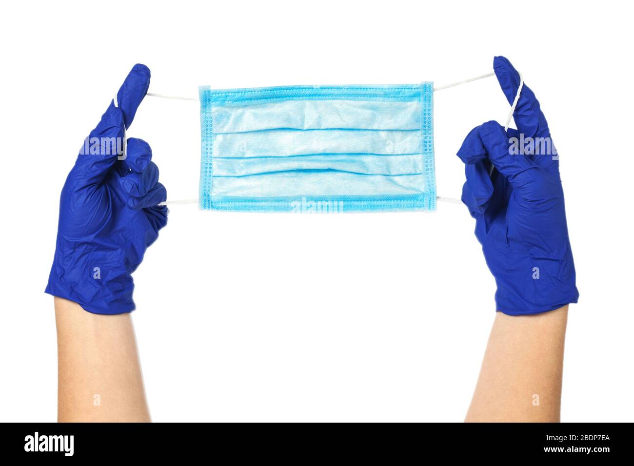 Le mani nei guanti di gomma contengono una maschera medica protettiva. Maschera chirurgica isolata su fondo bianco. Foto Stock