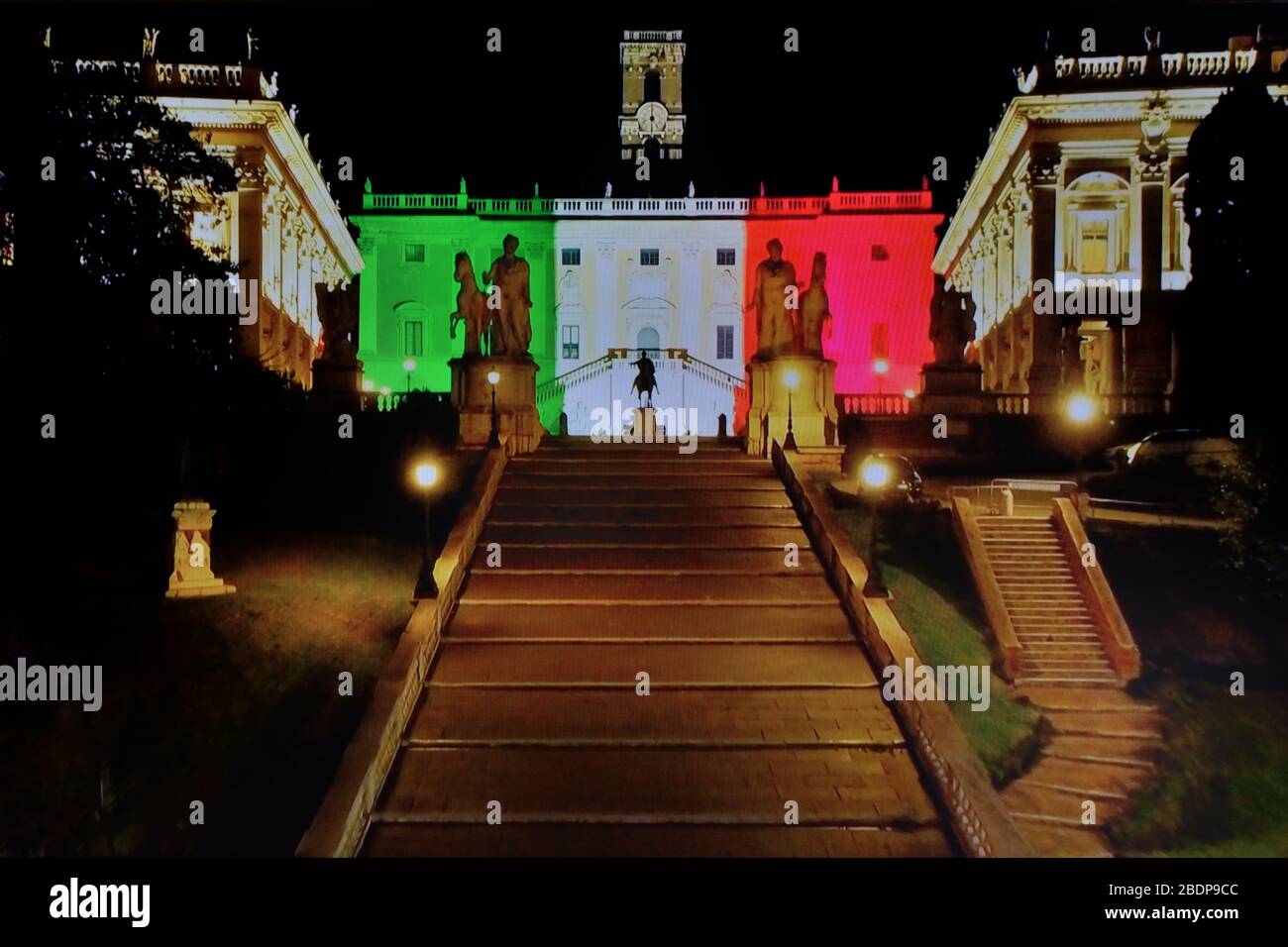Roma - Italia, vista notturna di Piazza Campidoglio (Palazzo senatorio dipinto con luce tricolore), deserta durante il blocco imposto dal governo pandemico coronavirus aprile 2020 Foto Stock