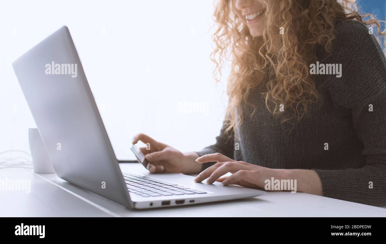 Donna che fa acquisti online utilizzando il suo laptop e una carta di credito, mani da vicino, e-commerce e online banking concetto Foto Stock