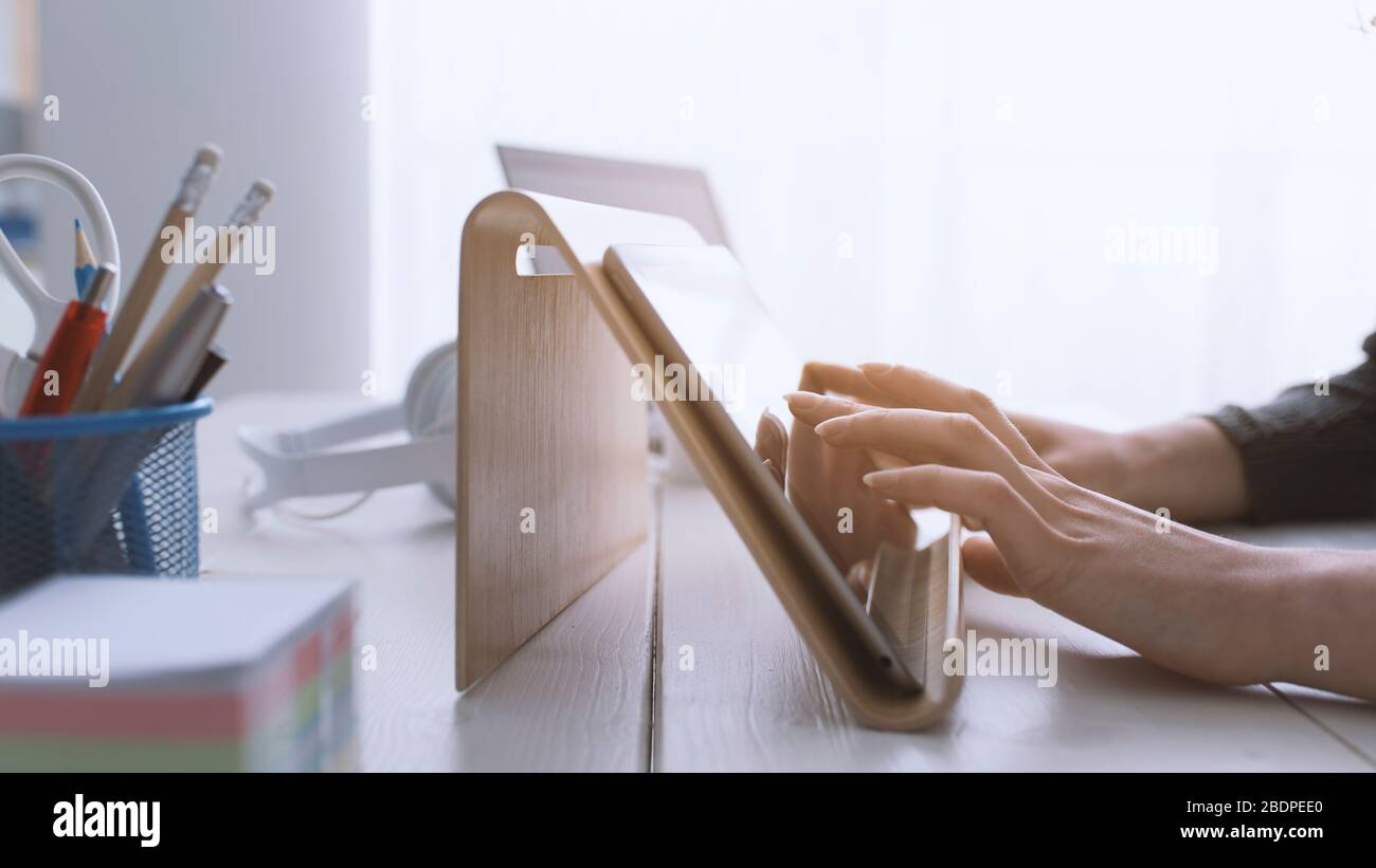 Donna che utilizza le app su un tablet digitale e navigazione sul Web, le mani si avvicinano Foto Stock