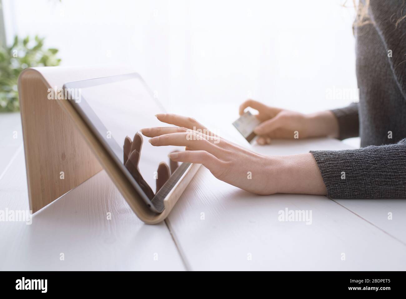Donna che usa le app su un tablet digitale e acquista online con una carta di credito, le mani si avvicinano Foto Stock