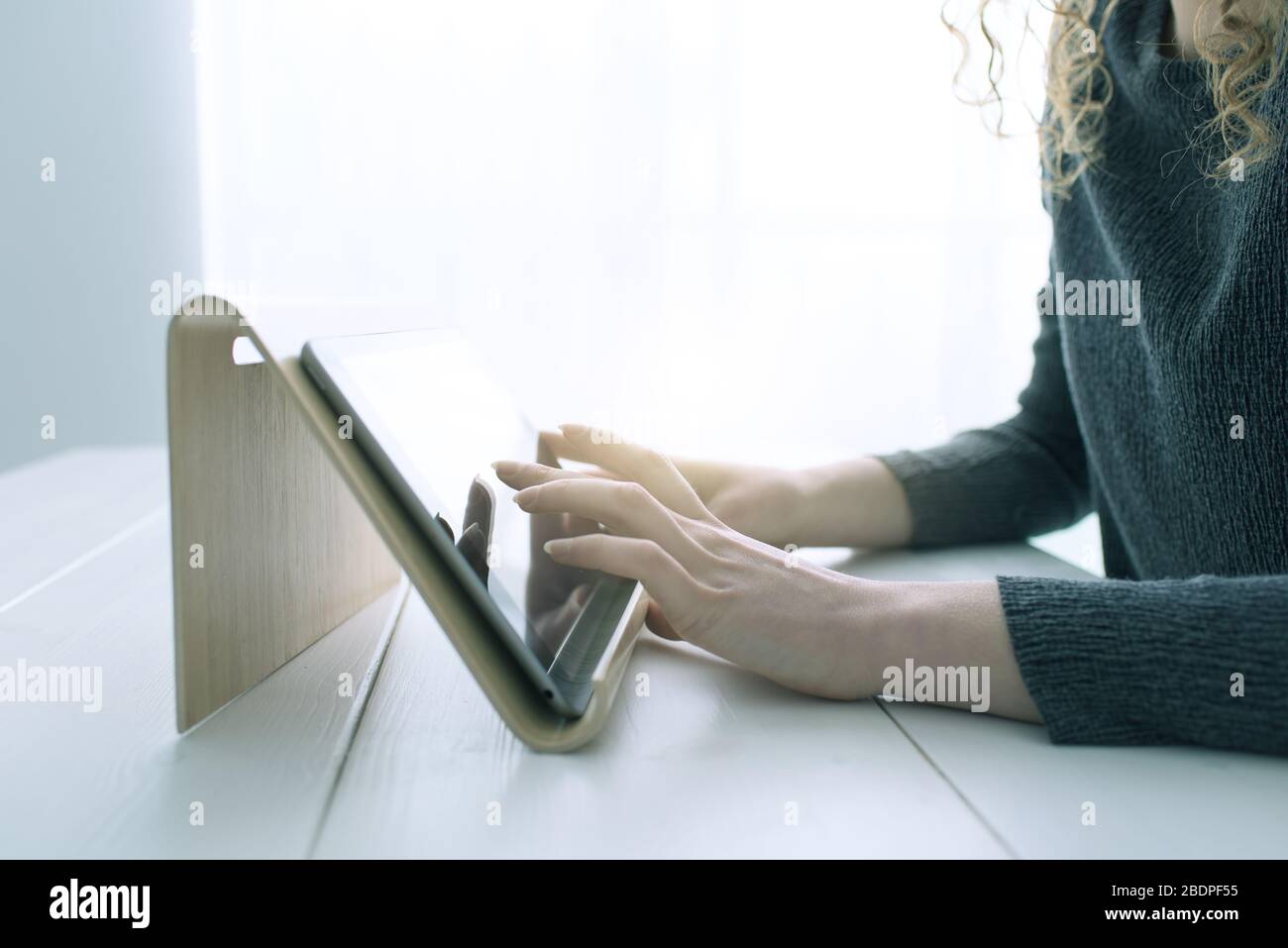 Donna che utilizza le app su un tablet digitale e navigazione sul Web, le mani si avvicinano Foto Stock