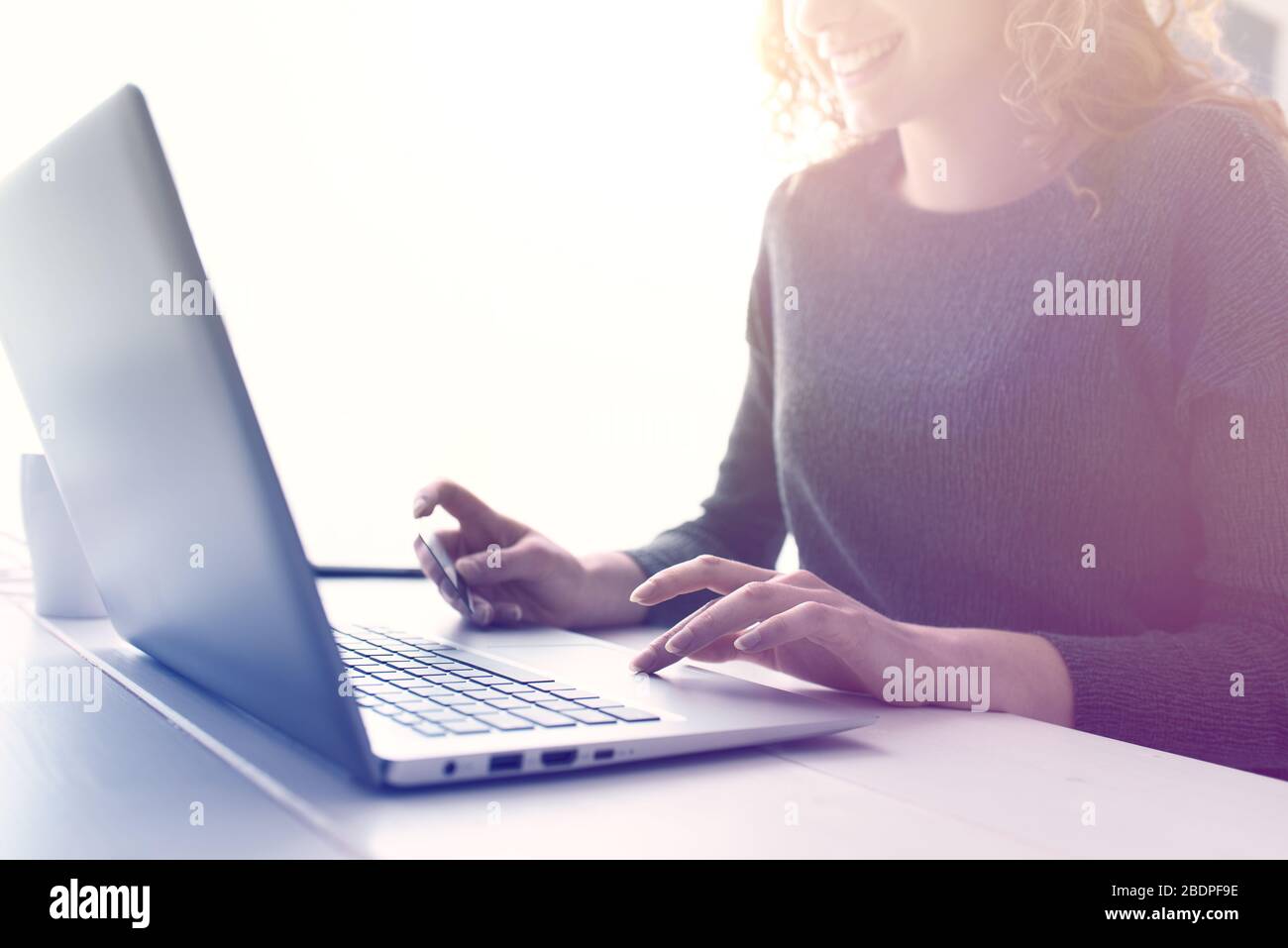 Donna che fa acquisti online utilizzando il suo laptop e una carta di credito, mani da vicino, e-commerce e online banking concetto Foto Stock