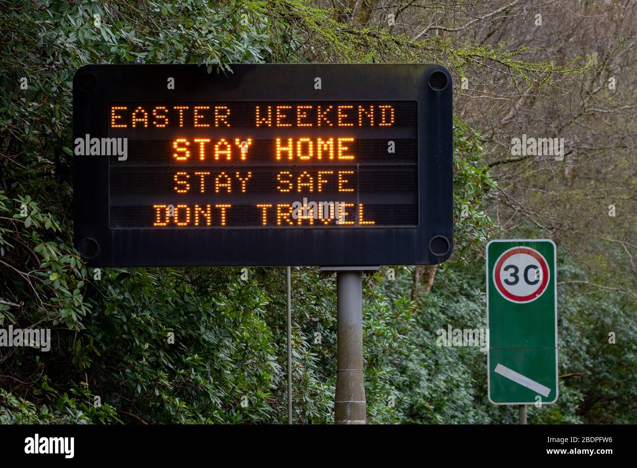 A82 a Tarbet di Loch Lomond, Scozia, Regno Unito. 9 Aprile 2020. Weekend di Pasqua preoccupazioni di viaggio - un segno sulla A82 appena fuori dal villaggio di Tarbet chiedendo alle persone di rimanere a casa e di non viaggiare oltre il weekend di pasqua Credit: Kay Roxby/Alamy Live News Foto Stock