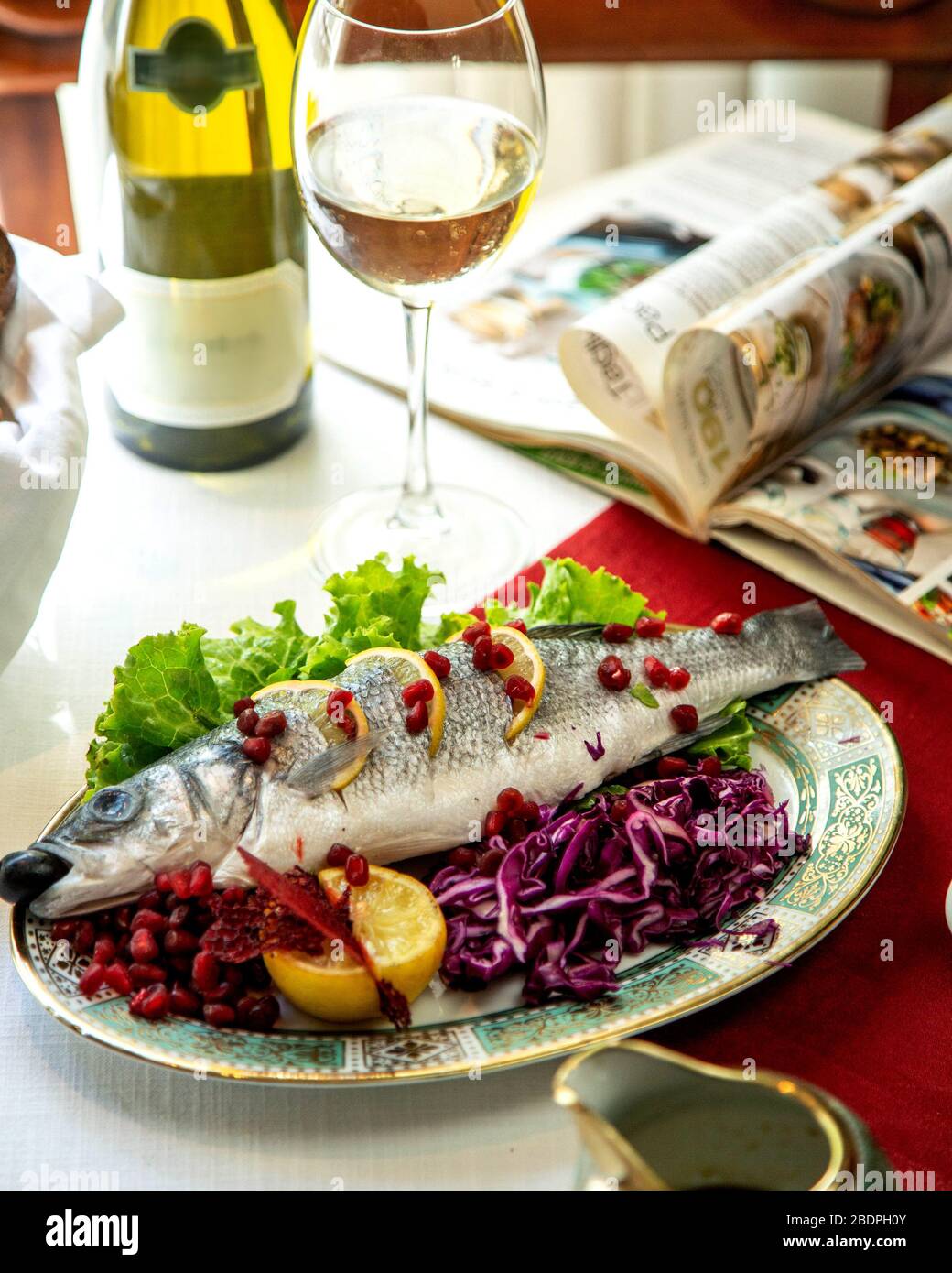 pesce con limone e melograno Foto Stock