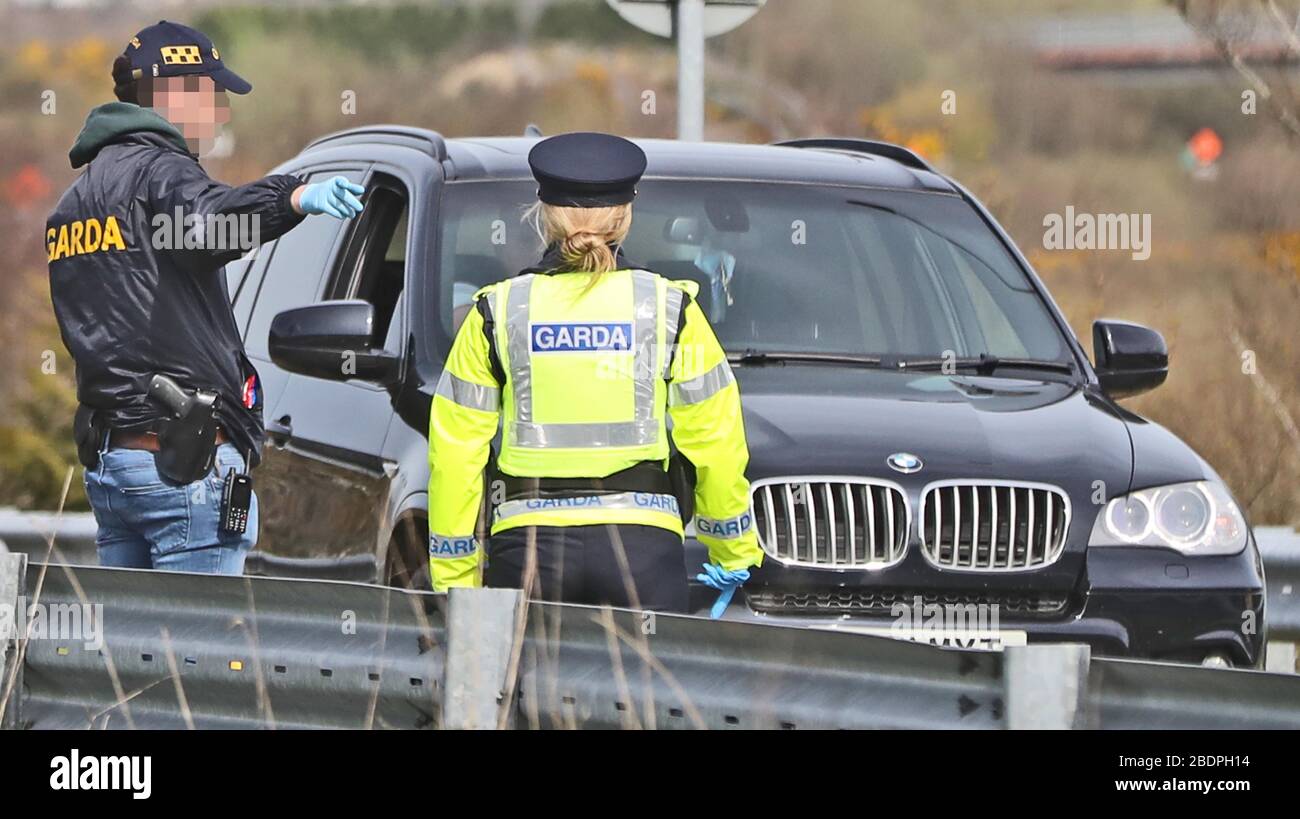 FACCIA PIXELATED DA PA PICTURE DESK Gardai compreso i detectives armati montano i checkpoint del coronavirus sul confine con l'Irlanda del Nord a Carrickarnon Co Louth. Foto Stock