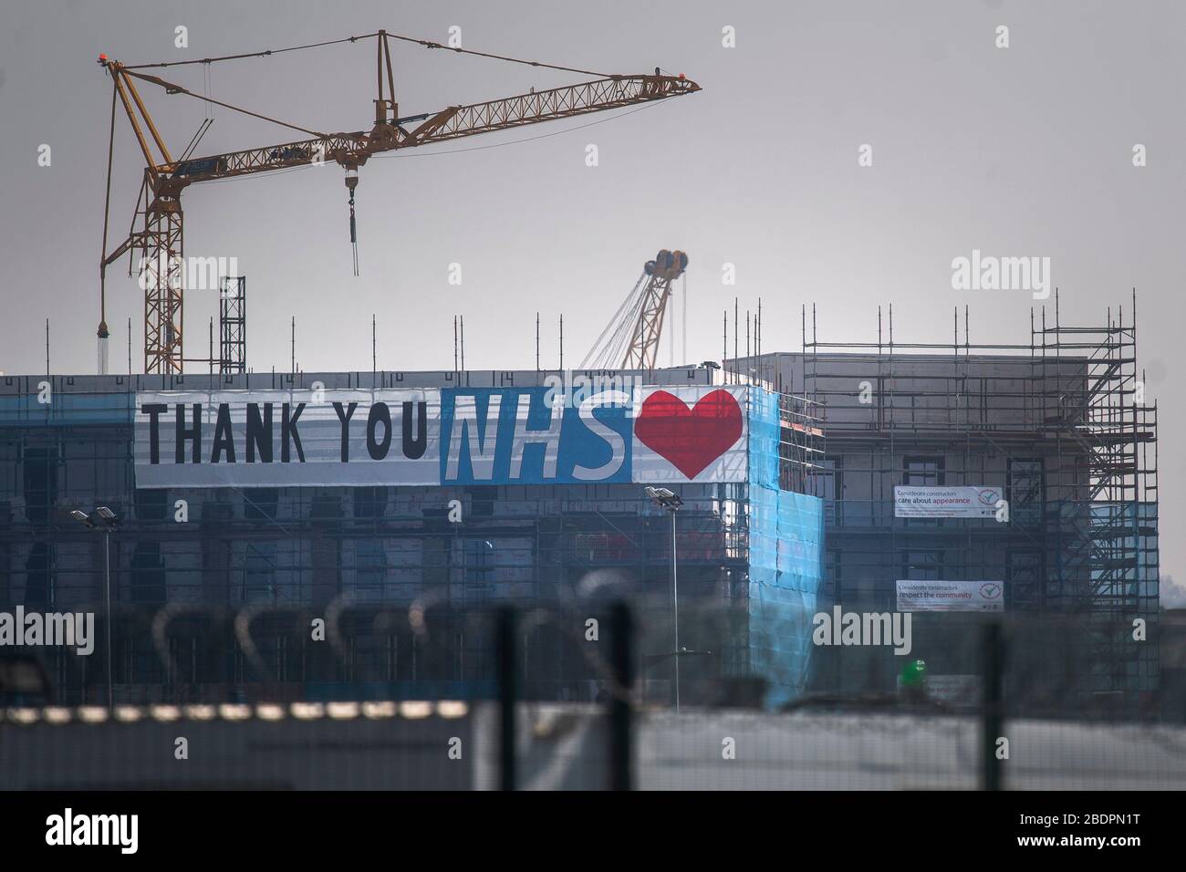 Un grande striscione che ringrazia l'NHS in un cantiere di fronte al centro Excel di Londra, un ospedale temporaneo con 4000 posti letto che è stato istituito per il trattamento dei pazienti di Covid-19. Foto Stock