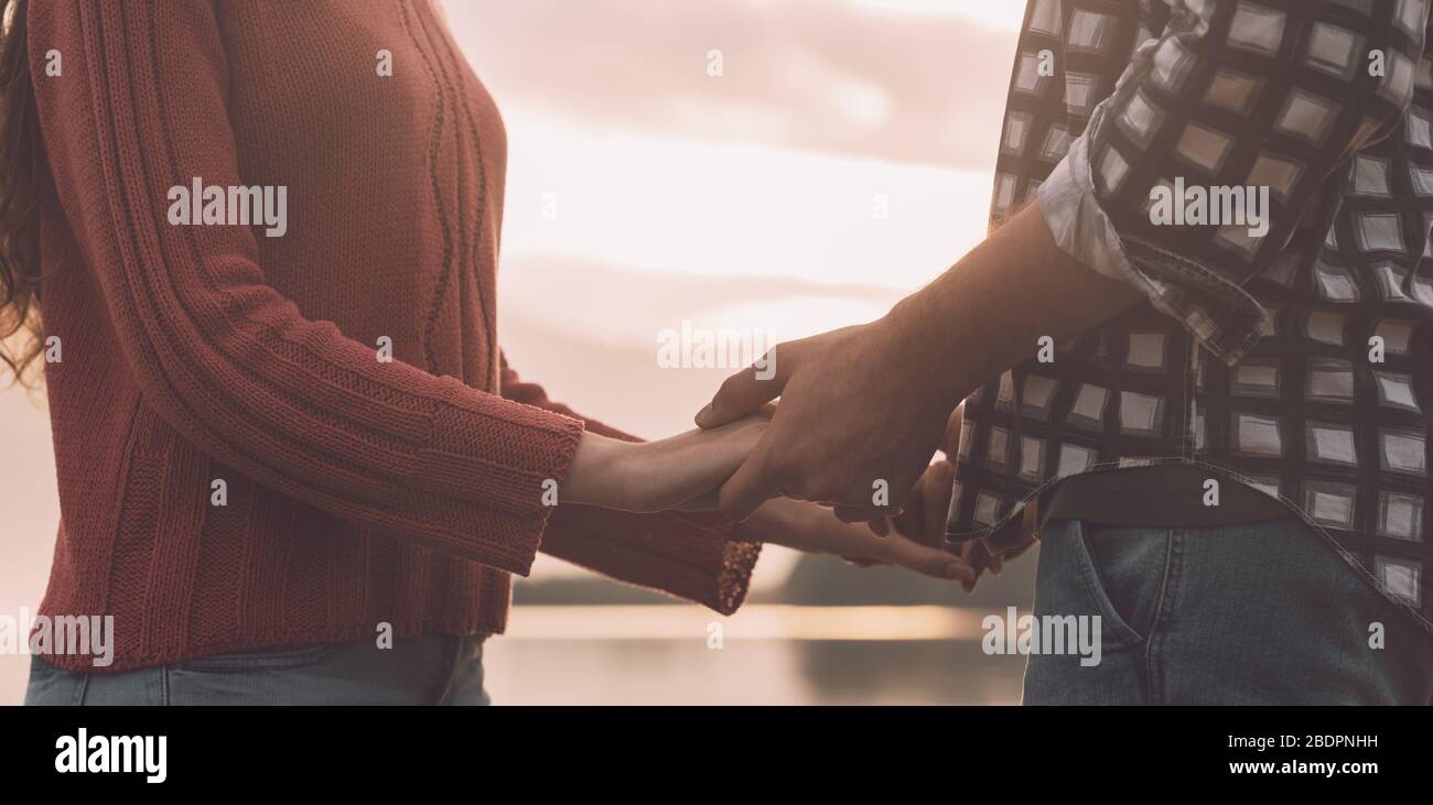 Coppia romantica giovane amorevole tenendo le mani al lago, sentimenti e relazioni concetto Foto Stock