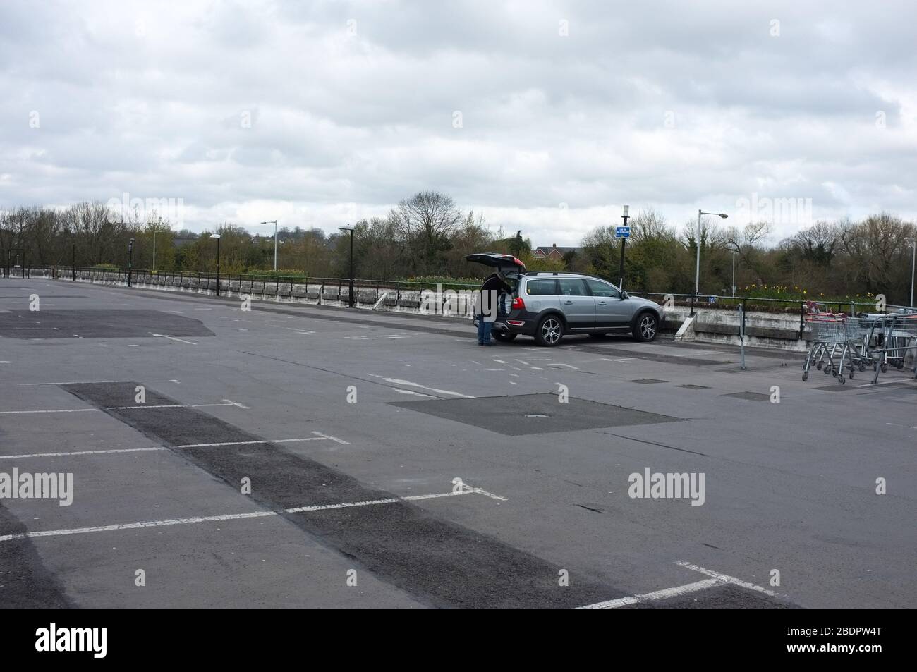 Un unico acquirente in un parcheggio deserte supermercato a Salisbury, Regno Unito durante la pandemia di coronavirus Covid 19 nel 2020. Foto Stock