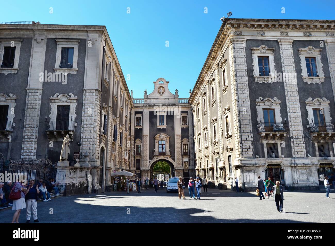 Antico edificio con pareti nere e colonne bianche, mattoni e finestre in una piazza italiana in una giornata di sole Foto Stock