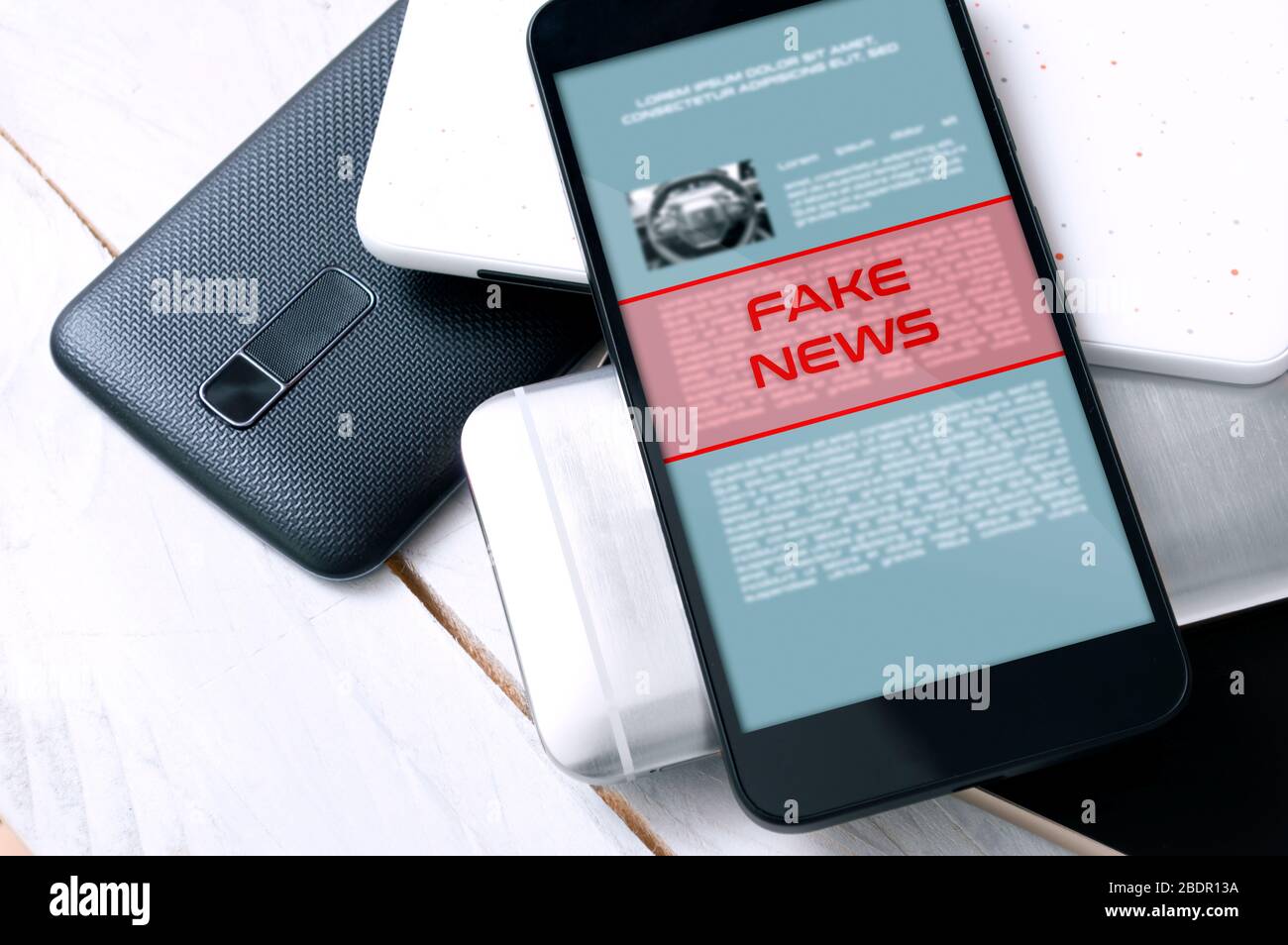 Stack di smartphone con l'avviso di "notizie false" nella parte superiore. Concezione di un livello crescente di notizie false. Foto Stock