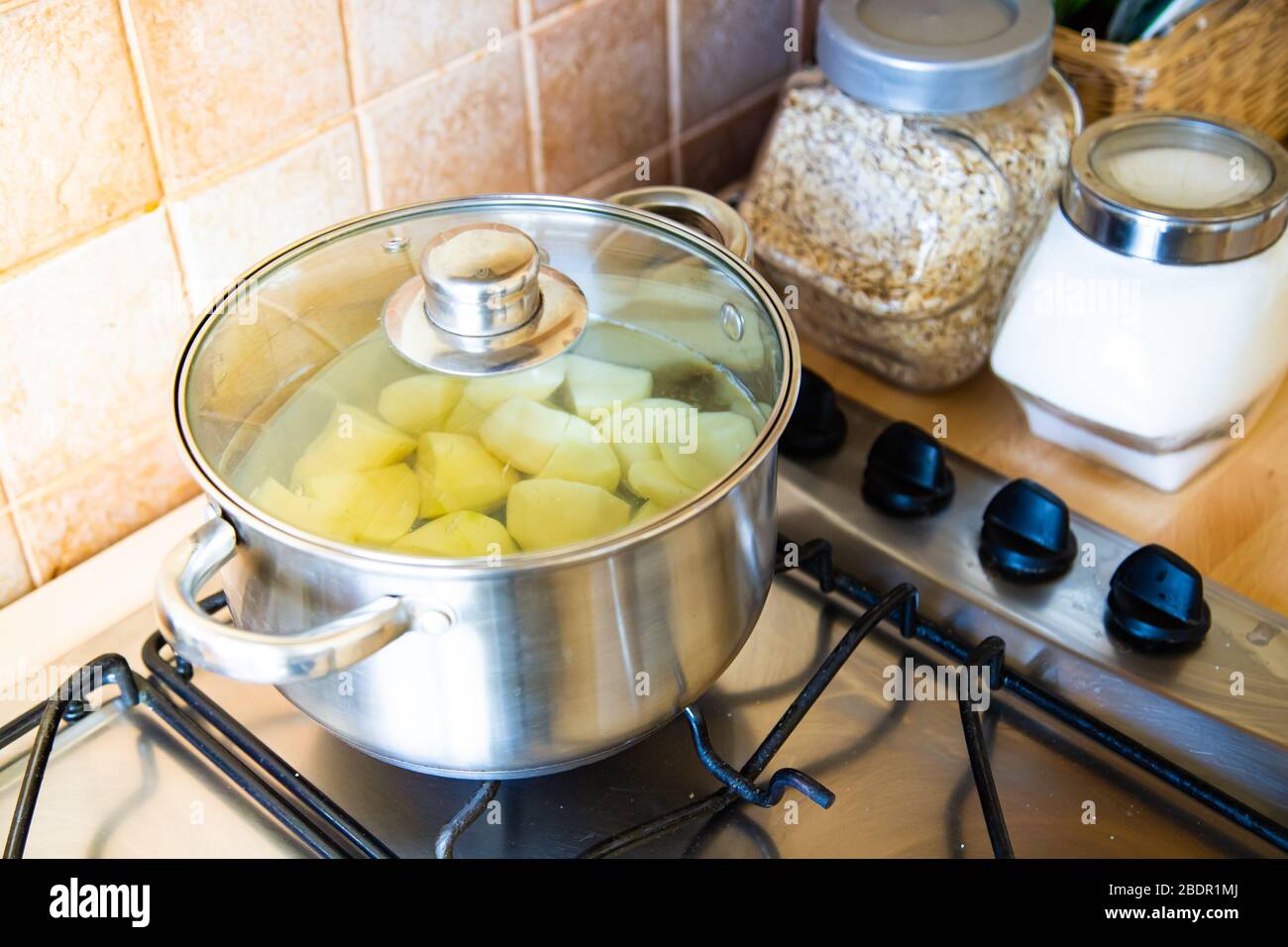 Patate bollenti nel recipiente in cucina Foto Stock