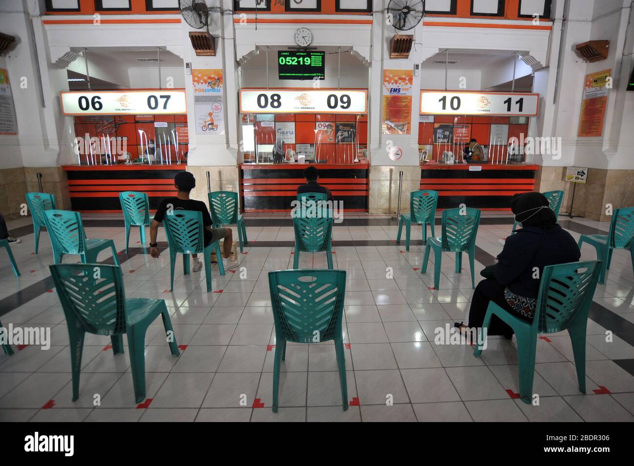 Yogyakarta, Indonesia. 9 Aprile 2020. Le persone si accodano sedendosi su una sedia a distanza sociale durante l'epidemia di COVID-19 all'ufficio postale di Yogykarta a Yogyakarta, Indonesia, 9 aprile 2020. Credit: Supriyanto/Xinhua/Alamy Live News Foto Stock