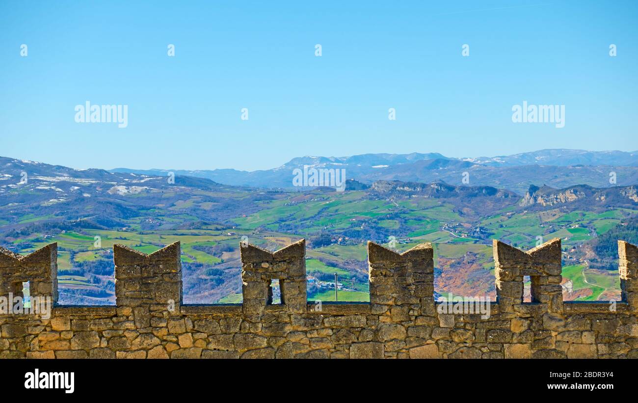 Antica cinta muraria di San Marino e montagne sullo sfondo Foto Stock