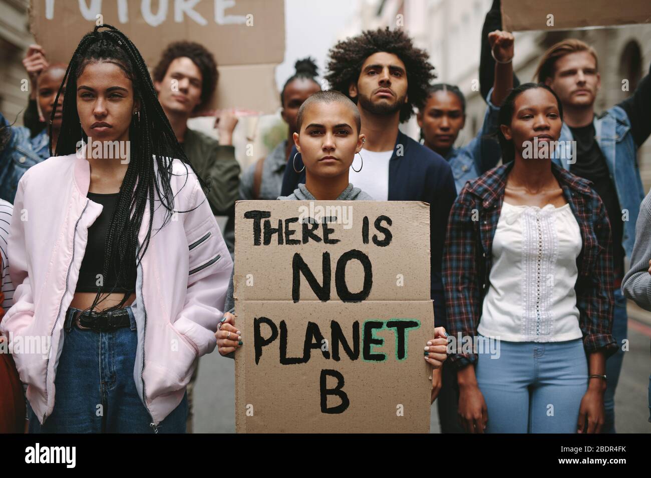 Gruppo di attivisti con striscioni che protestano contro l'inquinamento e il riscaldamento globale. Ribelli maschili e femminili che fanno una protesta silenziosa per salvare il pianeta terra. Foto Stock