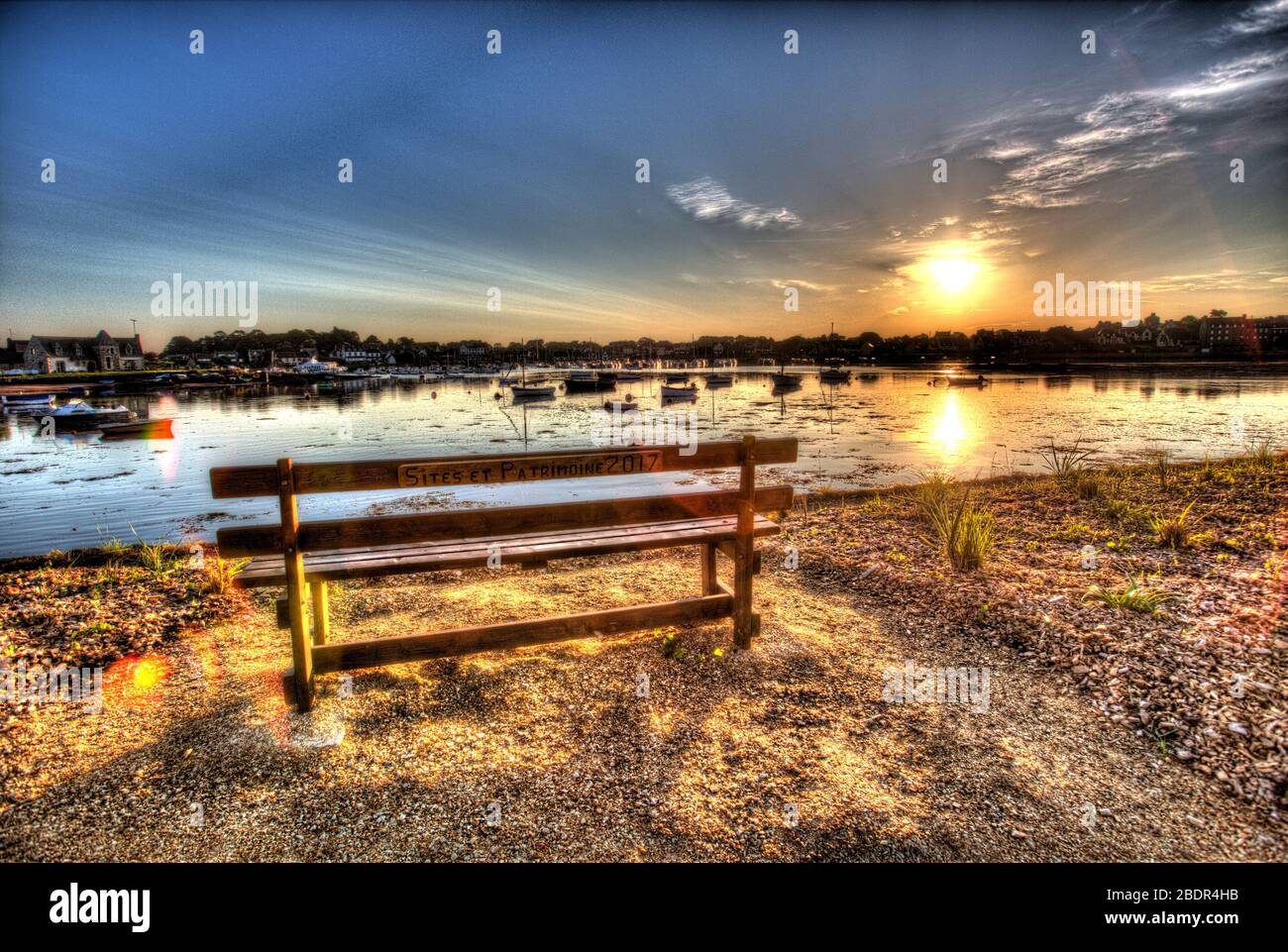 Villaggio di Plouhmanacc'h, Francia. Vista artistica dell'alba su un sedile a panchina vuoto nel Boulevard des Traouiero di Ploumanac'h. Foto Stock