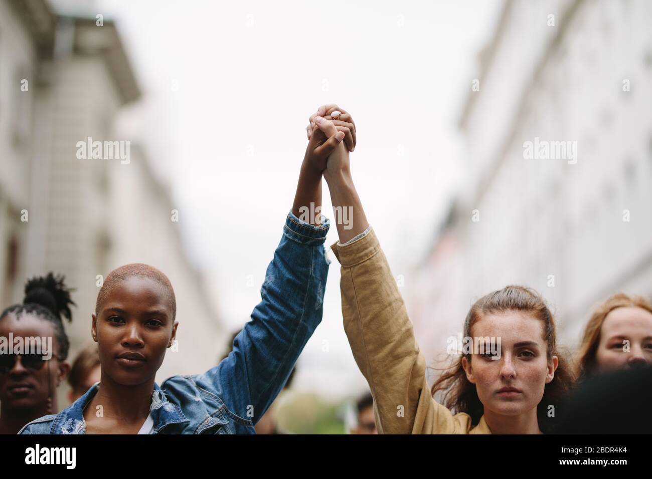 Gruppo di attivisti con mani in mano che protestano in città. Ribellioni che fanno la dimostrazione sulla strada tenendo le mani. Foto Stock Gruppo di attivisti con mani in mano che protestano in città. Ribellioni che fanno la dimostrazione sulla strada tenendo le mani. Foto Stock