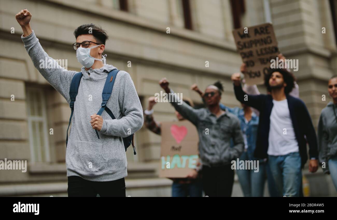 Gruppo di attivisti che protestano su strada. Persone che protestano insieme marciando con striscioni e dando slogan. Foto Stock Gruppo di attivisti che protestano su strada. Persone che protestano insieme marciando con striscioni e dando slogan. Foto Stock