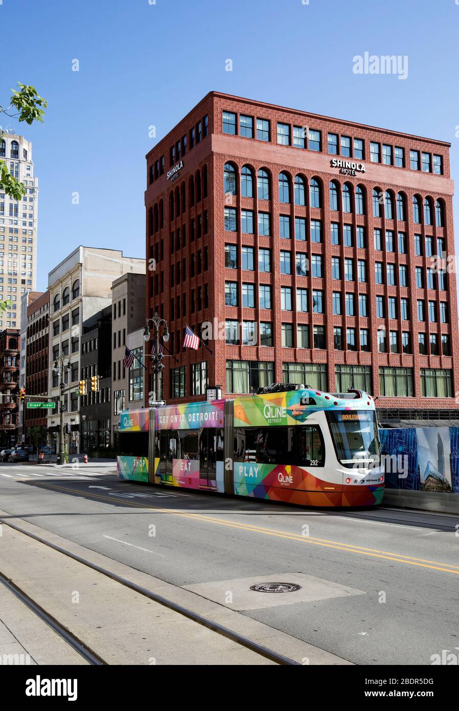 Il tram QLINE si muove lungo Woodward Avenue nel centro di Detroit, Michigan. Sullo sfondo si trova l'Hotel Shinola. Foto Stock