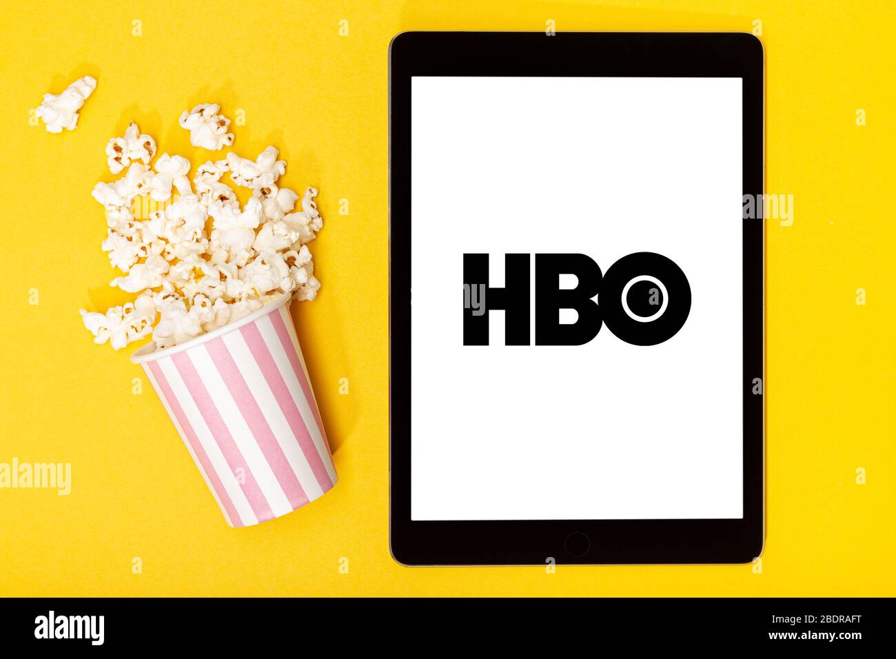Galizia, Spagna. 9 marzo 2020; secchio e tablet Popcorn con logo HBO su sfondo giallo. Vista dall'alto Foto Stock