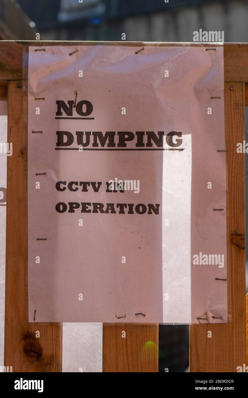 Un segno su una recinzione con le parole NO dumping CCTV in funzione scritto su di essa Foto Stock