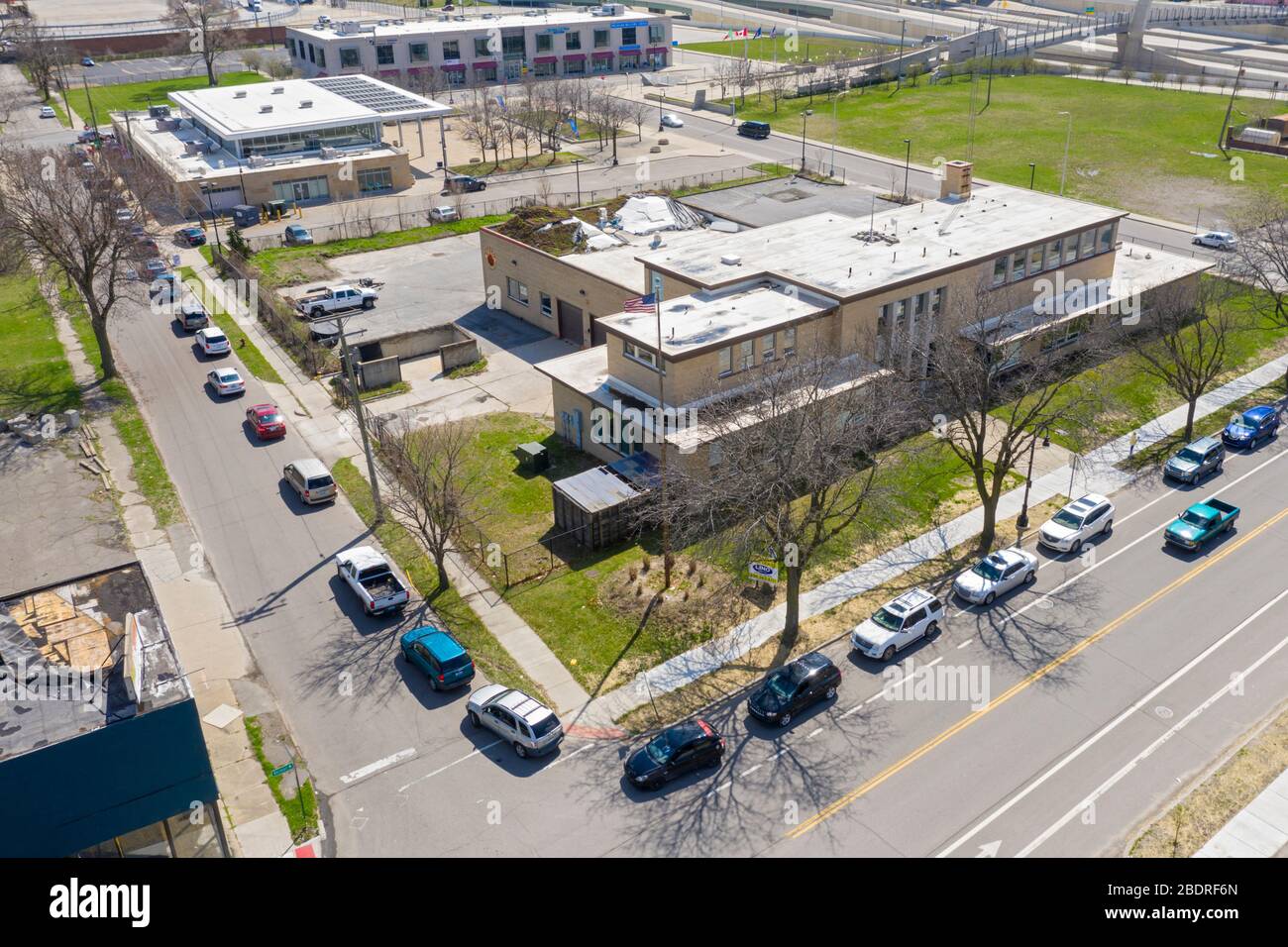 Detroit, Michigan, Stati Uniti. 8 Aprile 2020. Durante la crisi del coronavirus, la Gleaners Community Food Bank distribuisce cibo gratuito ai residenti in difficoltà nel sud-ovest di Detroit. Una linea di auto in attesa avvolge il blocco. Credit: Jim West/Alamy Live News Foto Stock