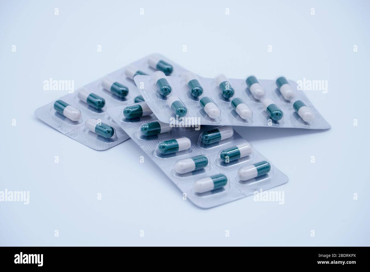 Pillola medica verde-bianca in background luminoso Foto Stock