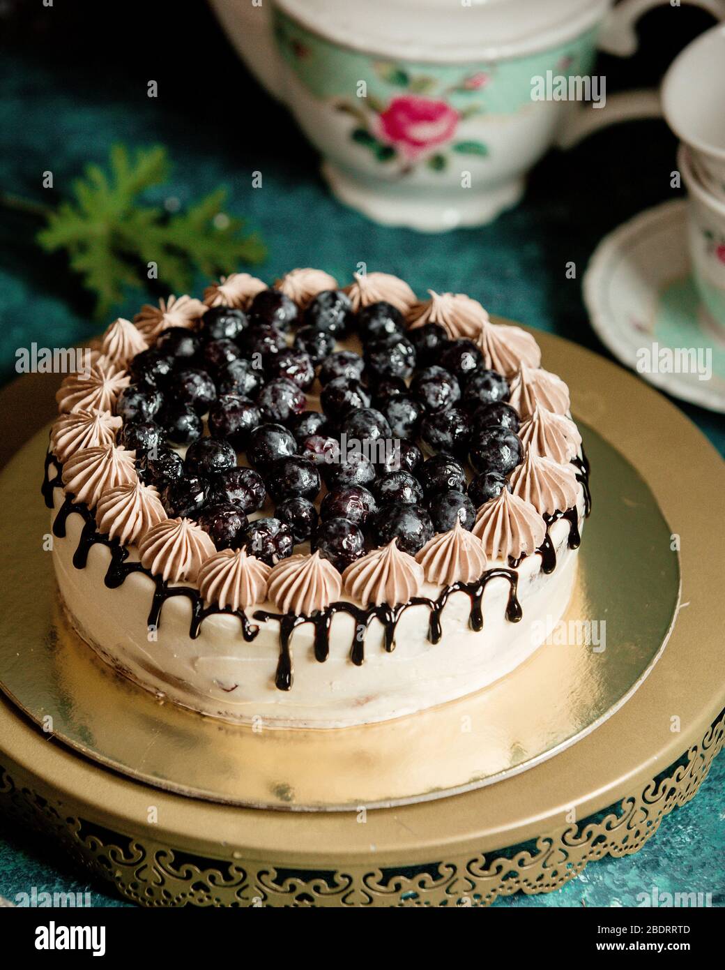torta classica decorata con sciroppo di cioccolato e mirtilli Foto Stock