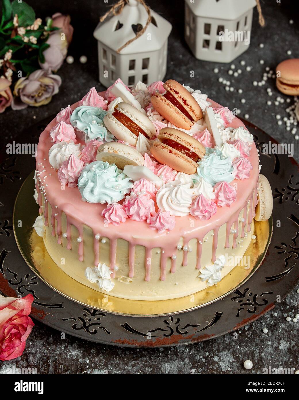 torta di gocciolamento crema rosa guarnita con crema rosa e blu e macaroon Foto Stock