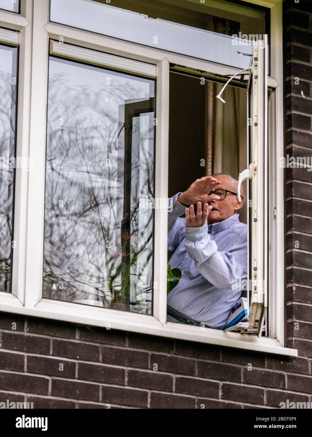 Harrogate, North Yorkshire, Regno Unito. 9 Aprile 2020. John Shannon, che ha 103 anni, è uscito dalla sua finestra per celebrare i nostri dipendenti chiave del NHS come parte dell'iniziativa Clap for Our Carers. John ha ricevuto il premio Point of Light in Society del primo Ministro per il suo lavoro volontario nella comunità quando aveva 101 anni. Come ufficiale navale in tempo di guerra aiutò a fondare la Sezione belga della Royal Navy e nel 2013 fu invitato ad aprire la prima base della Marina belga. Credit: ernesto rogata/Alamy Live News Foto Stock