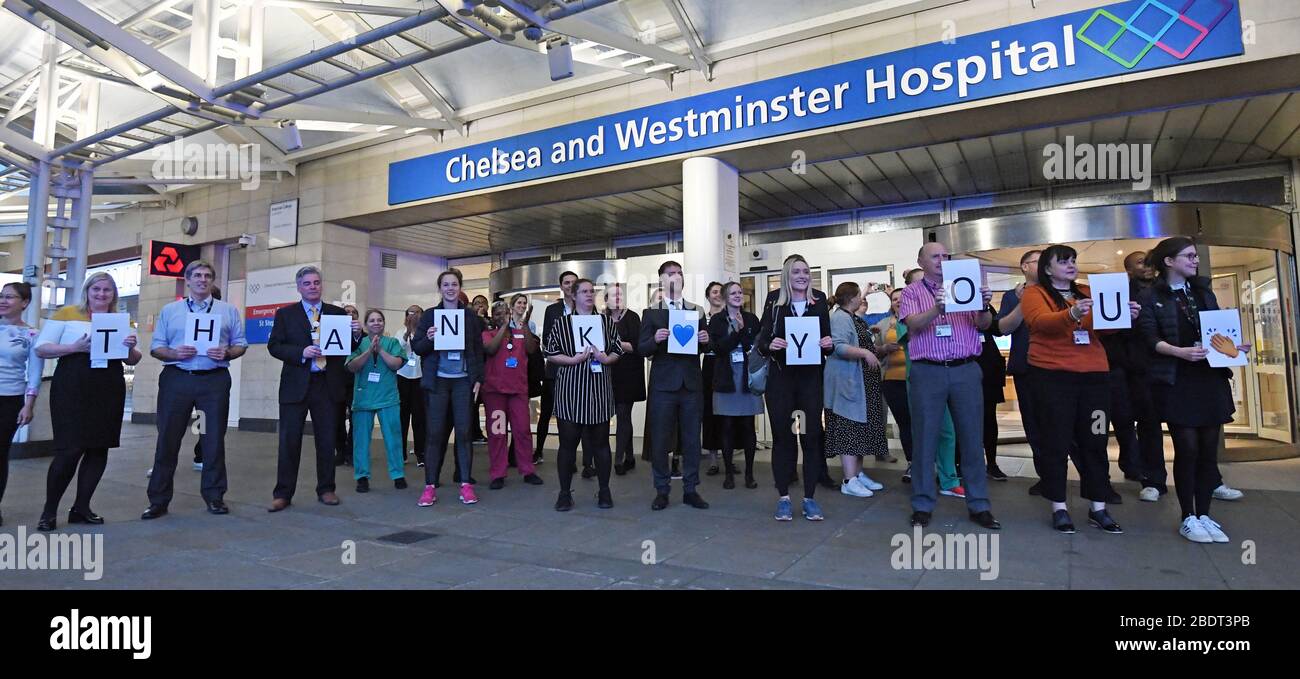 Il personale del Chelsea e Westminster Hospital di Londra ha applaudito i segnali di ringraziamento durante l'iniziativa Clap for Carers di giovedì a livello nazionale per applaudire i lavoratori del NHS che combattono la pandemia del coronavirus. Foto Stock