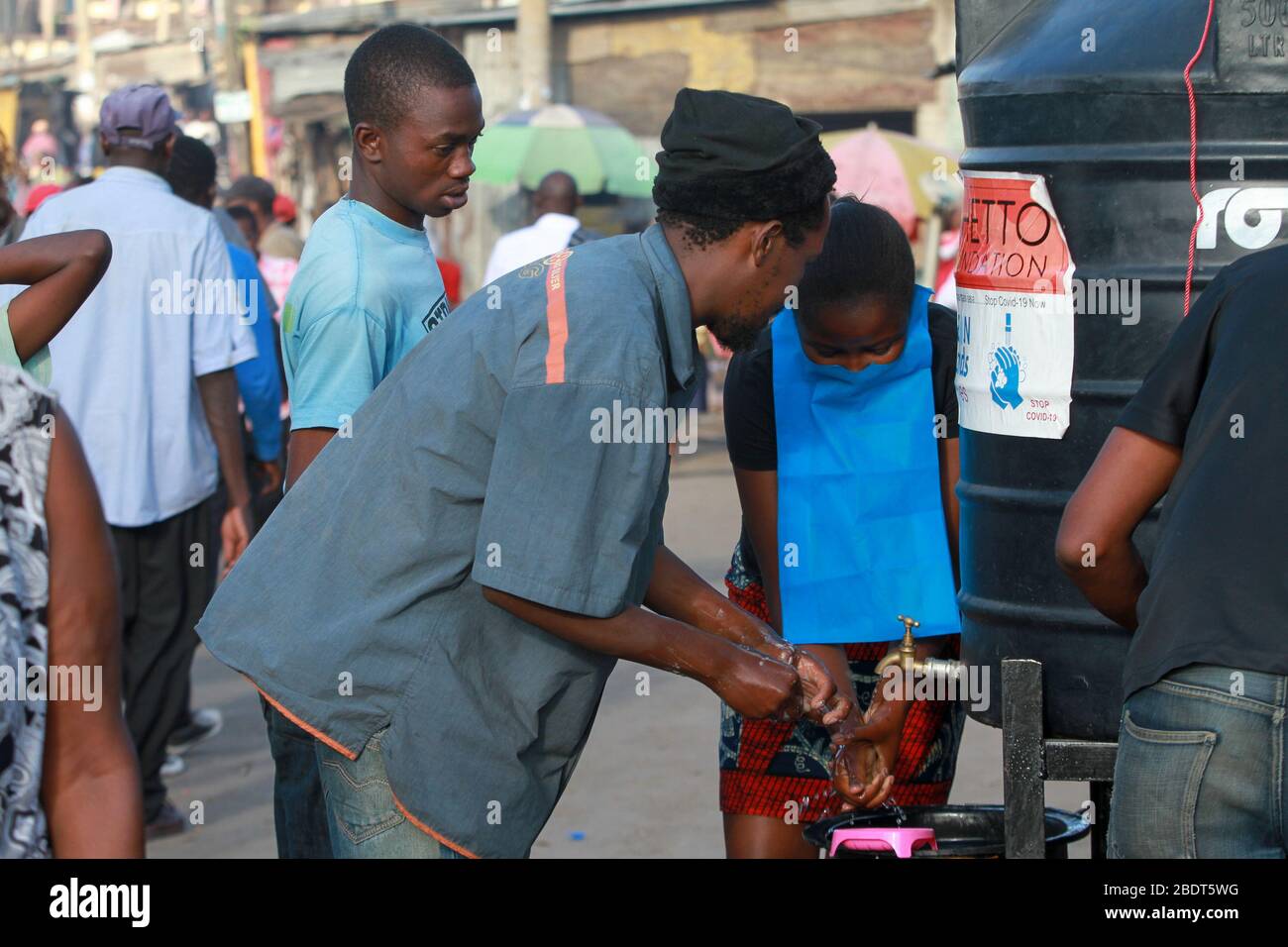 I kenyani lavano le mani con sapone e acqua su una strada dopo che la Fondazione Ghetto ha distribuito serbatoi d'acqua e sapone.questi articoli sono stati su richiesta dopo la direttiva del governo sull'uso delle maschere facciali mentre nei luoghi pubblici. Lunedì 6 aprile, il presidente keniota Uhuru Kenyatta ha annunciato la cessazione di 21 giorni del movimento dentro e fuori Nairobi e delle contee di Kilifi, Kwale e Mombasa a causa della diffusione del COVID-19 in queste regioni. Questo è seguito a un coprifuoco notturno (dalle 19:00 alle 5:00) che era stato imposto pochi giorni prima. Foto Stock