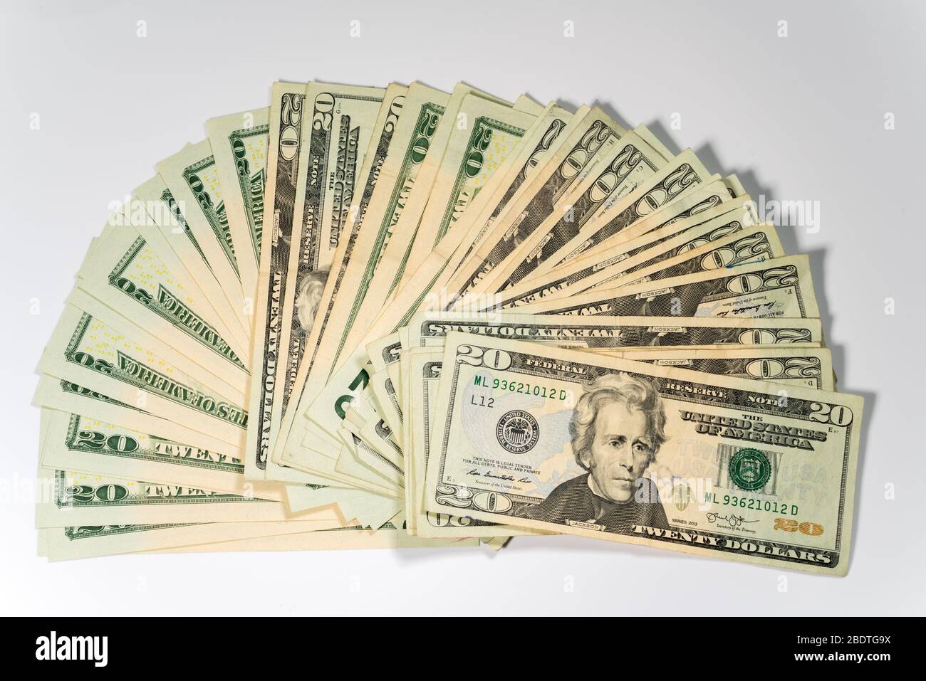 Migliaia di dollari USA disposti in forma di fan con 20 dollari di bollette contro uno sfondo bianco Foto Stock