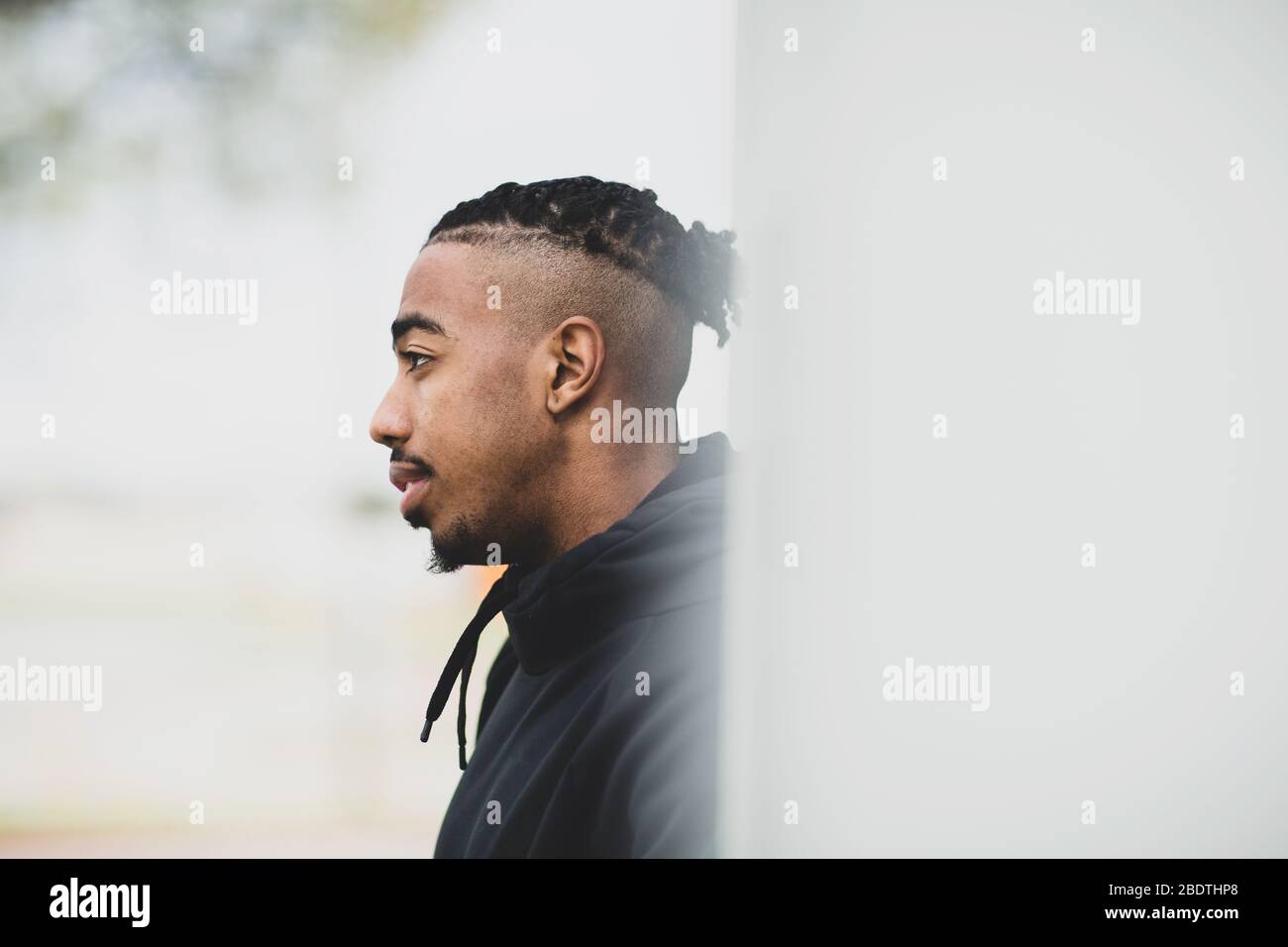 Giovane americano africano uomo fuori indossando un hoddie. Foto Stock