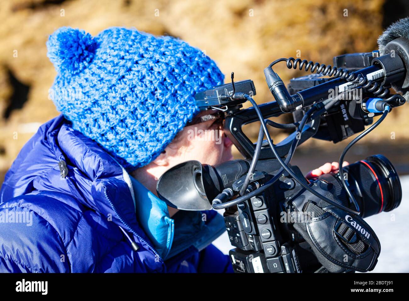 Un operatore di telecamere femminile che filma in Islanda Foto Stock
