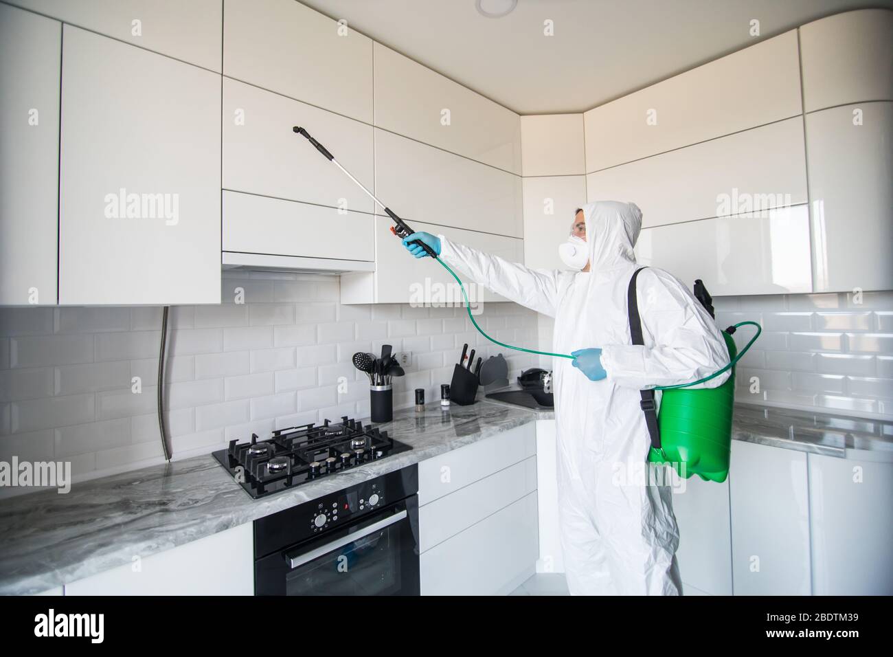 Disinfettante in tuta protettiva per la disinfezione in aree contaminate. Disinfettante professionale contro COVID-19, coronavirus. In tuta da vestiario Foto Stock