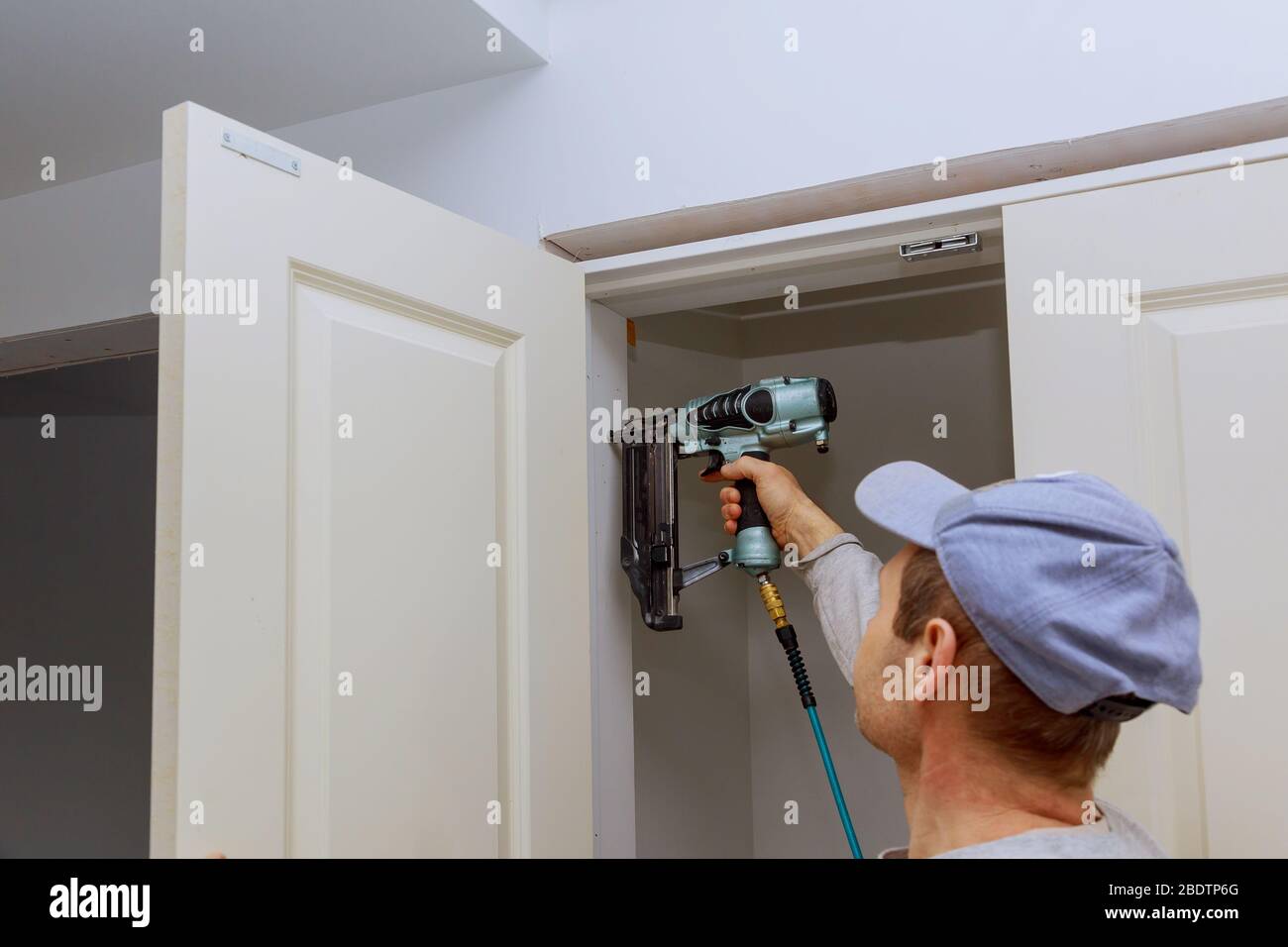 Installazione di porte interne per ambienti con pistola pneumatica per  chiodi Foto stock - Alamy
