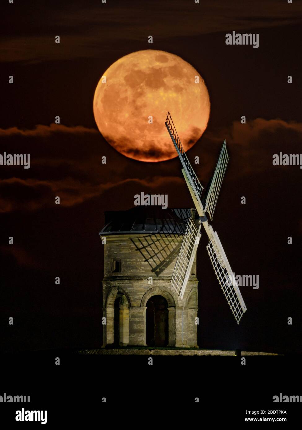 Luna piena (superluna) che sorge dietro il mulino a vento di Chesterton, Warwickshire, Regno Unito. Immagine singola (non composita) acquisita con obiettivo a lunghezza focale lunga. Foto Stock