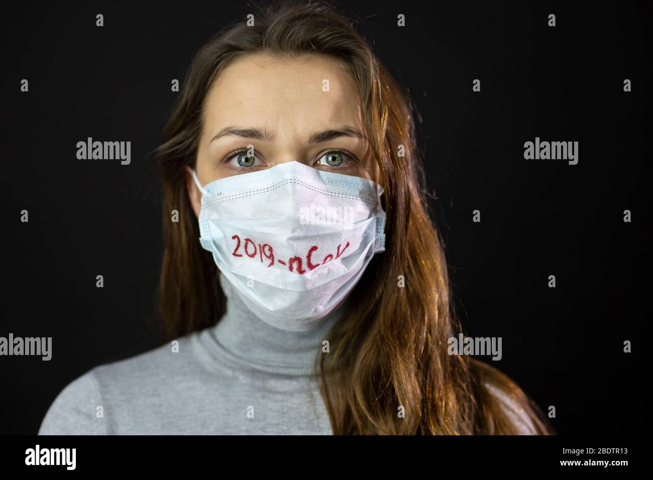 Ritratto di donna spaventata di coronavirus in maschera medica con 2019-ncov scritto Foto Stock
