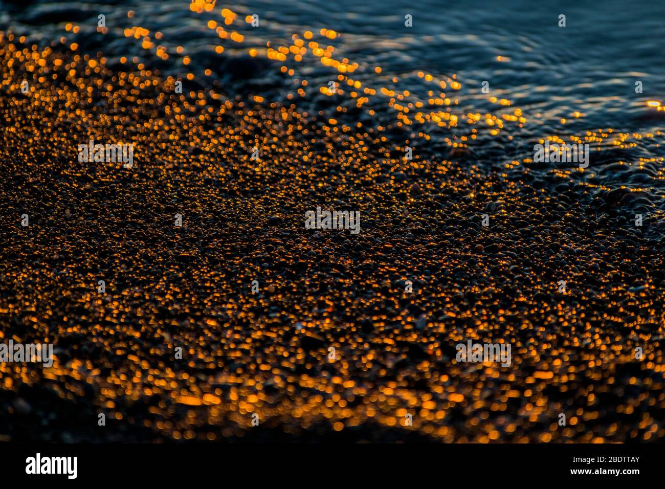 Ciottoli all'alba, pietre e acqua sulla spiaggia Foto Stock