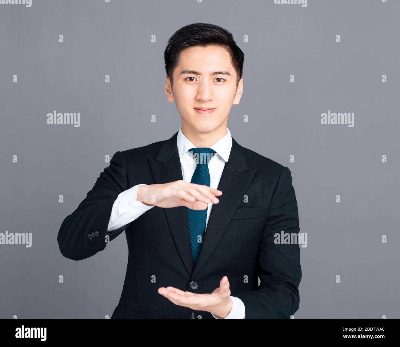 giovane uomo d'affari con tenere e mostrare il gesto Foto Stock