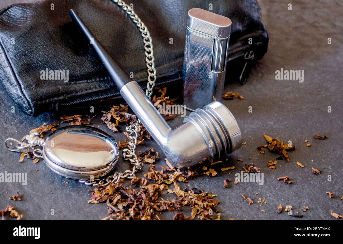 tubo in aristocob con custodia in pelle e accessori, vecchio accendino in pietra focaia e tabacco sfuso Foto Stock